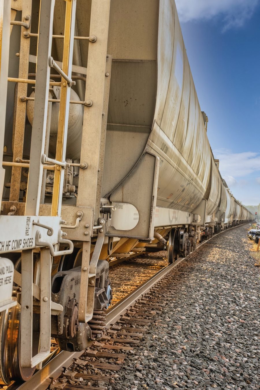 Looking down the length of a line of hopper cars from beside the ladder